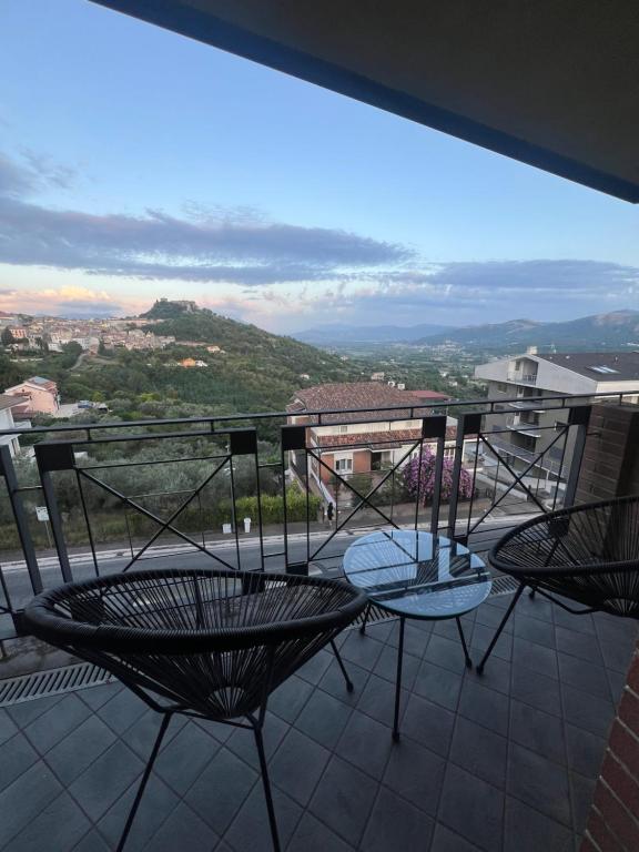 a balcony with two chairs and a view of a city at In My Place in Caiazzo