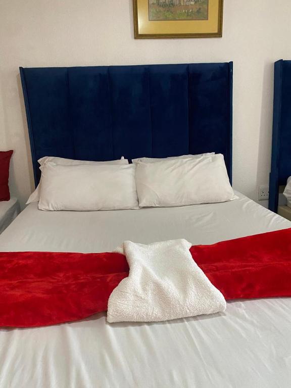 a bed with a red and white blanket on it at two lovers in Vosburg