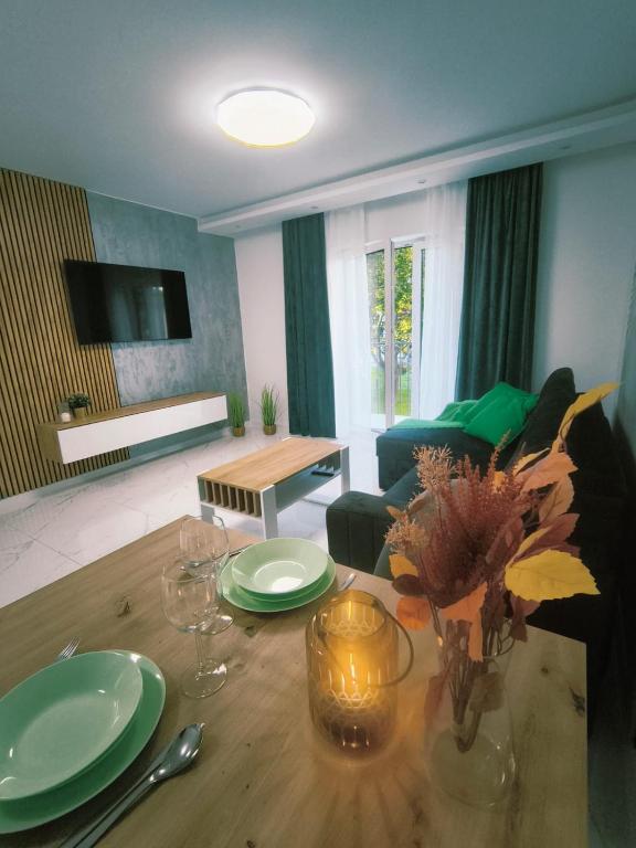 a living room with a table and a living room with a couch at Aura Apartamenty in Brzeg