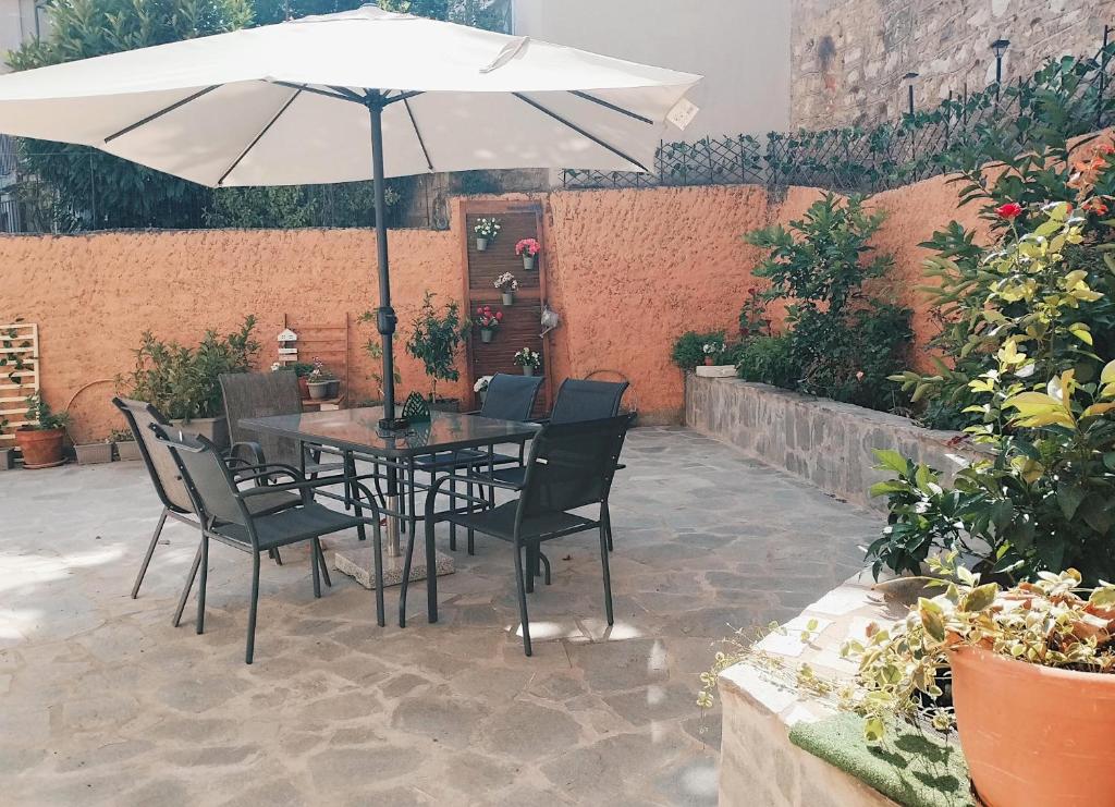 a table and chairs with an umbrella on a patio at MaFi Apartment in Ioannina