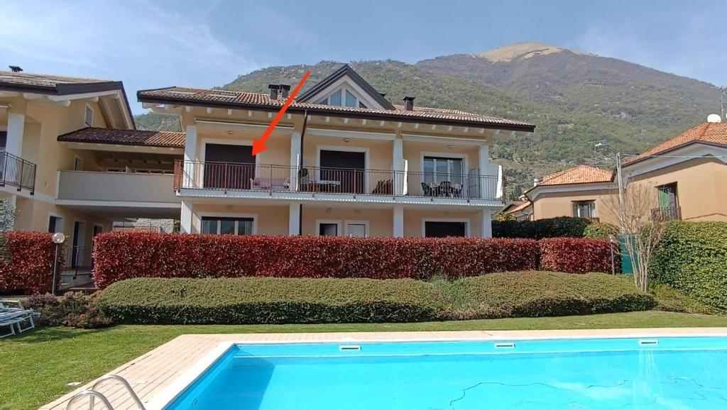 a house with a red arrow on top of it at Duplex with terrace , pool, 2 bedrooms in Lenno