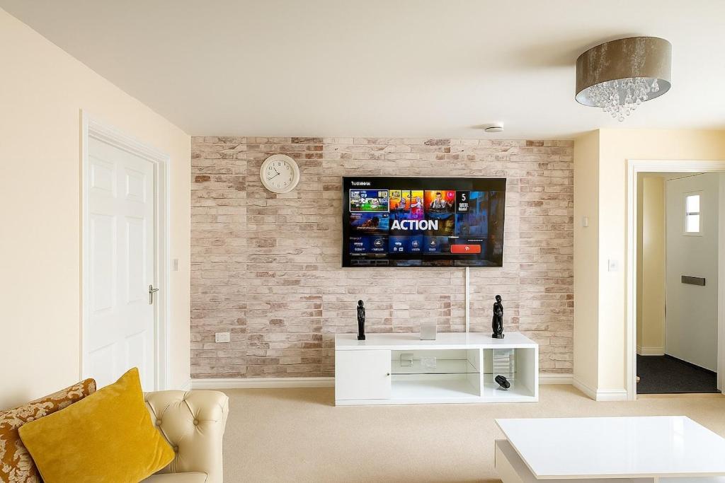a living room with a tv on a brick wall at Rosengelyn Apartment in Sheffield