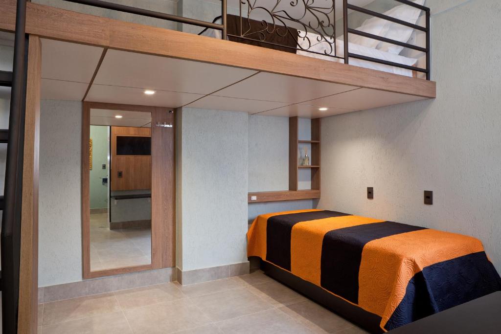 a bedroom with an orange and black bed in a room at LOFT LAPA Baldô in Rio de Janeiro