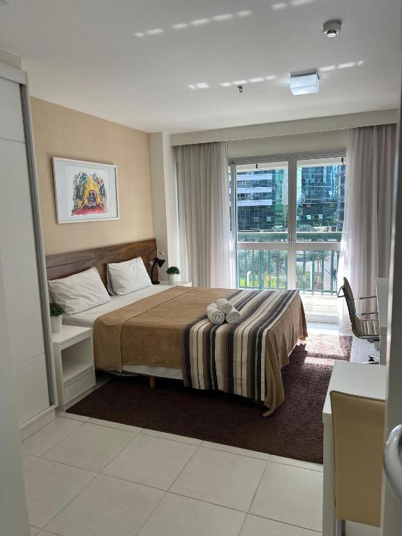 a bedroom with a bed and a large window at Maravilhoso Flat Vision in Brasilia