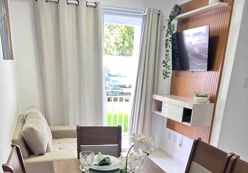 un salon avec une table et une fenêtre dans l'établissement Arara Paraense, à Ananindeua