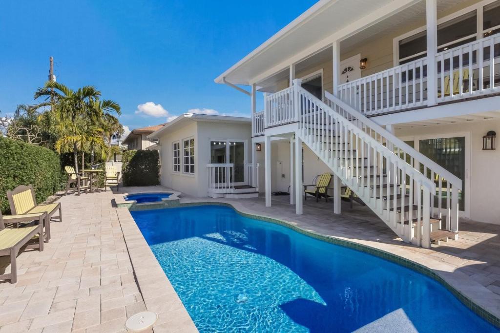 a home with a swimming pool in front of a house at Surf Riders home in Holmes Beach