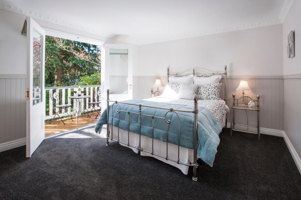a bedroom with a bed and a balcony at Clarendon Cottages in Sassafras