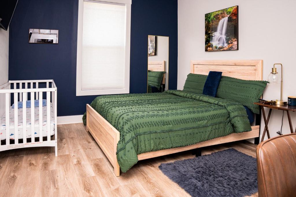 a bedroom with a green bed and a crib at Getaway to heaven in McMinnville