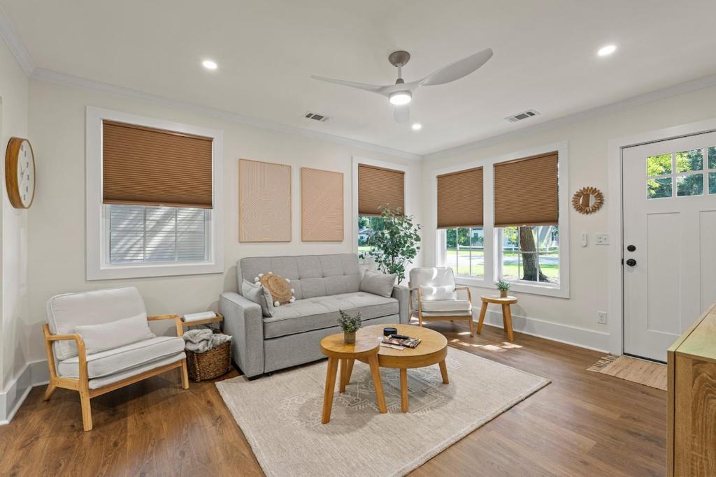 ein Wohnzimmer mit einer Couch und einem Tisch und Stühlen in der Unterkunft Pinky's Palace Cozy Bungalow in Port Royal