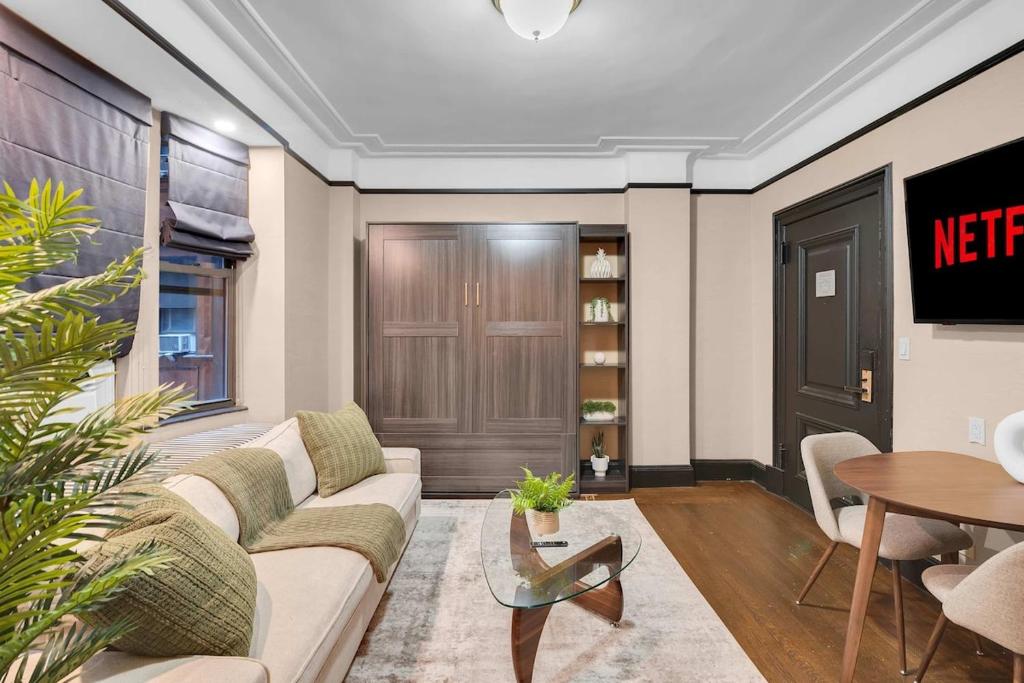 a living room with a couch and a table at Unbeatable Location The Heart of NYC 1 BDR W GYM in New York