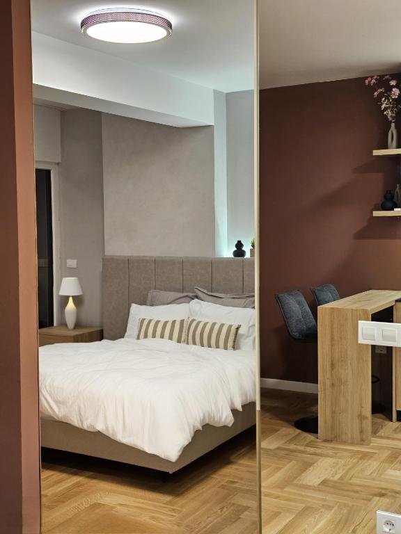 a bedroom with a large bed and a table at Blush Studio at Rose in Prishtinë