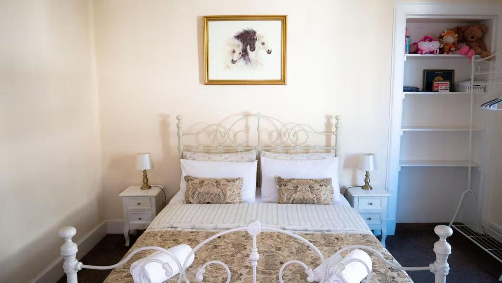 a bedroom with a white bed with two night stands at Cozy Central Apartment in Inverness