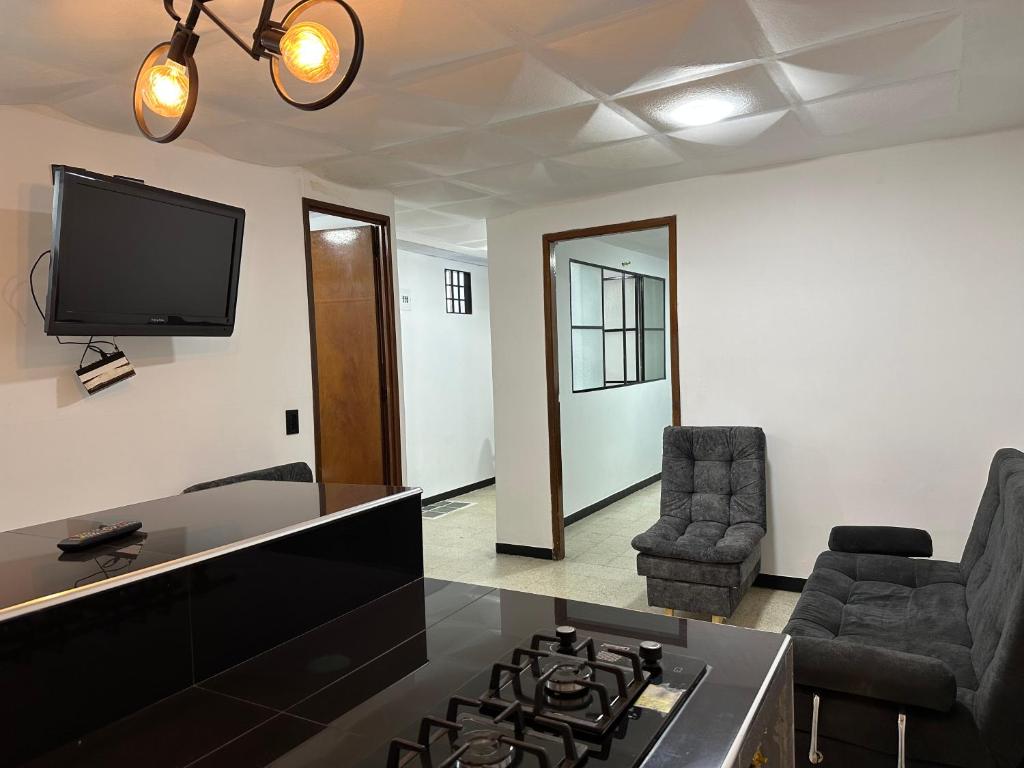 a living room with a stove and a tv on the wall at Apartamentos FM 212 in Líbano