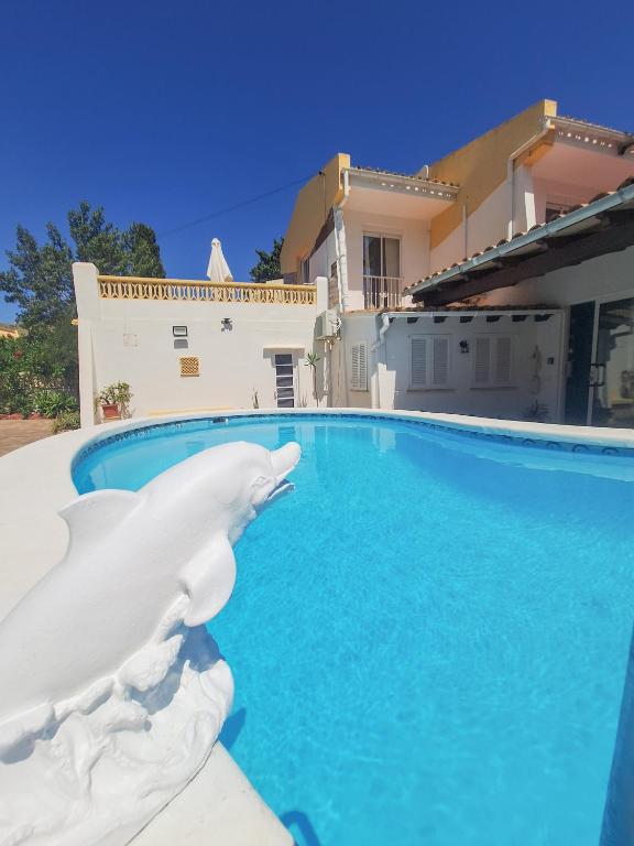 a white bird statue next to a swimming pool at Villa Nevada - Espacioso Chalet con Piscina Privada y Salita de Cine in Port de Pollensa
