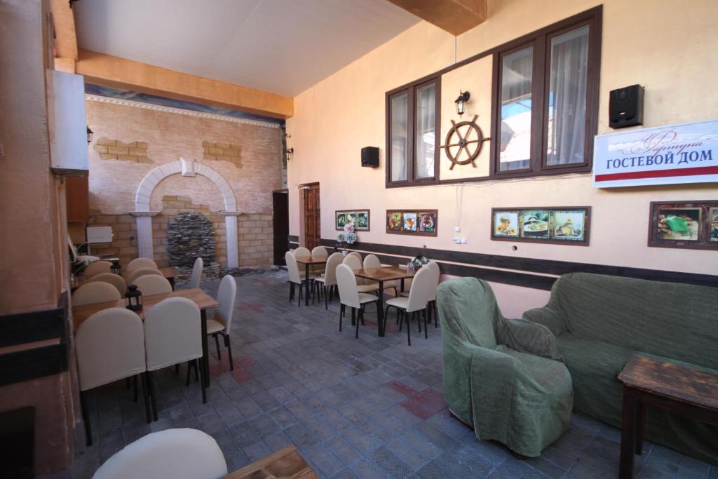 a dining room with tables and chairs in a restaurant at Guest House on Kirova 78 in Anapa