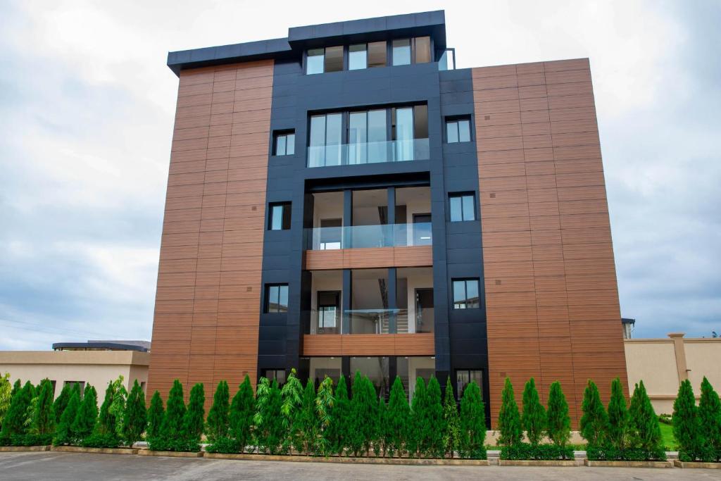 wysoki budynek z drzewami przed nim w obiekcie Maison Paraíso, apartamento de lujo 1Hab w mieście Ciudad de Malabo