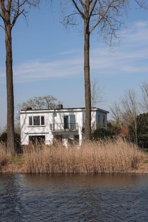 a house on the shore of a body of water at Villa Kint in Damme