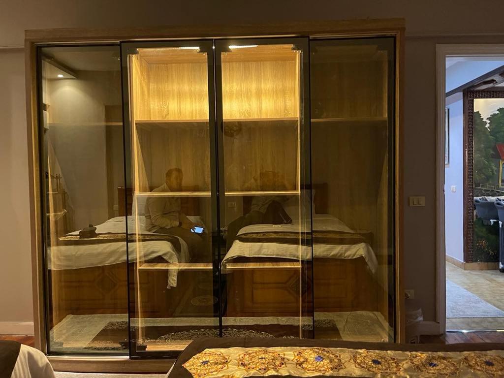 a glass case with a bed in a room at Modern Super Lux Mohandessin Flat Perfect for Gulf Travelers in Cairo