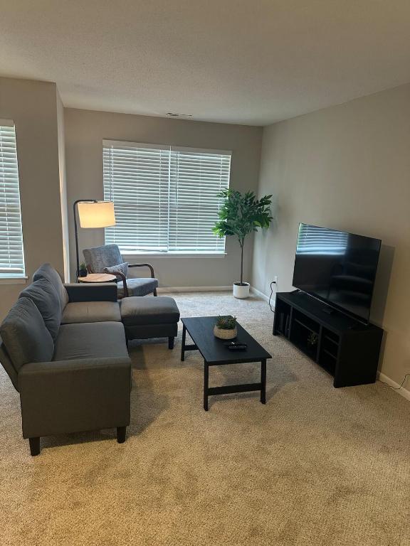 a living room with a couch and a flat screen tv at Relax & Work Cozy 1 BR Apt in Durham
