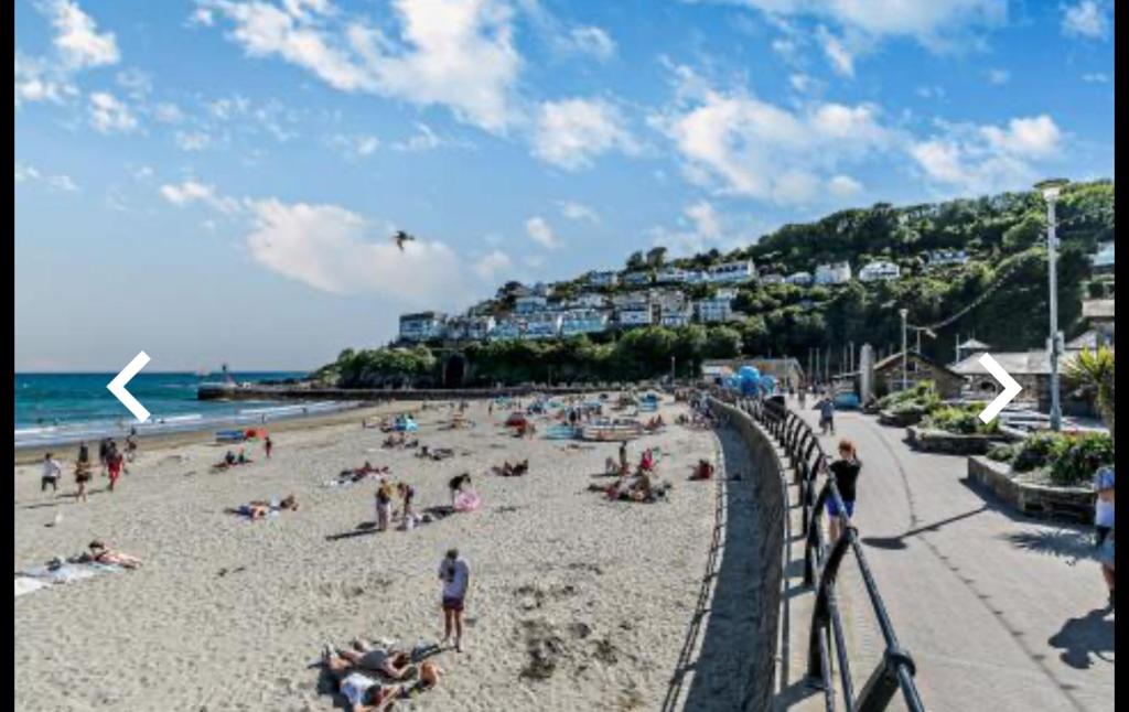 a group of people on a beach near the ocean at Looe Holiday Home in Looe