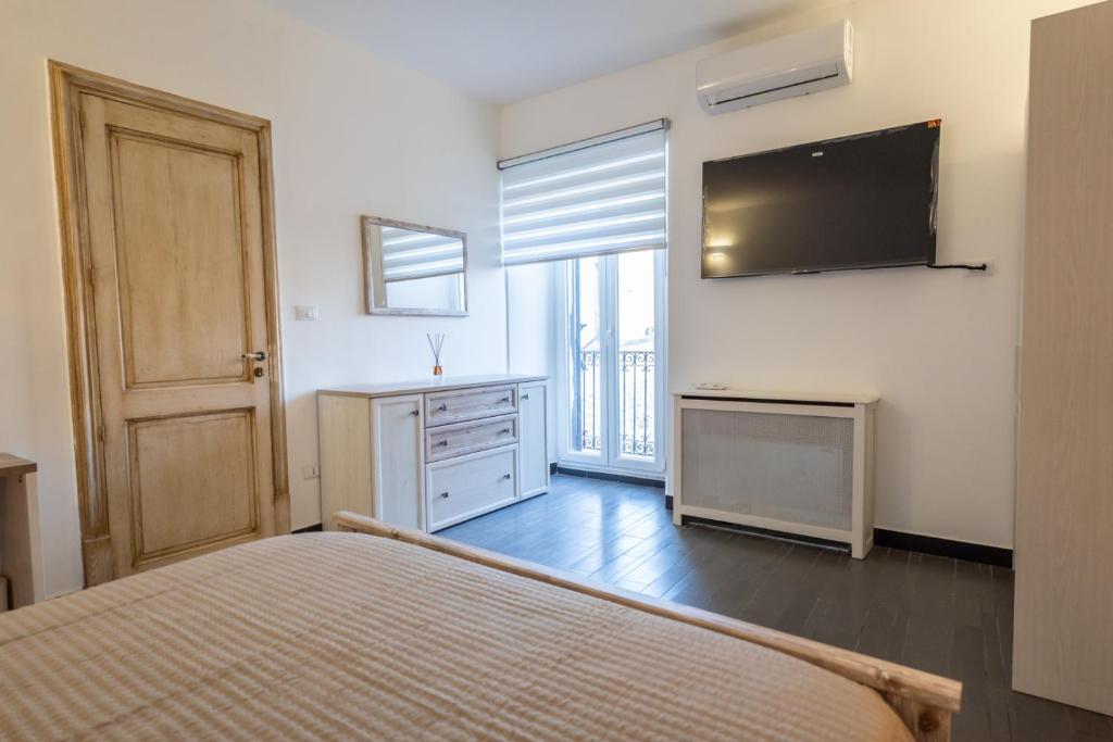 a bedroom with a bed and a television on the wall at Alcantara Domus in Roccella Valdemone