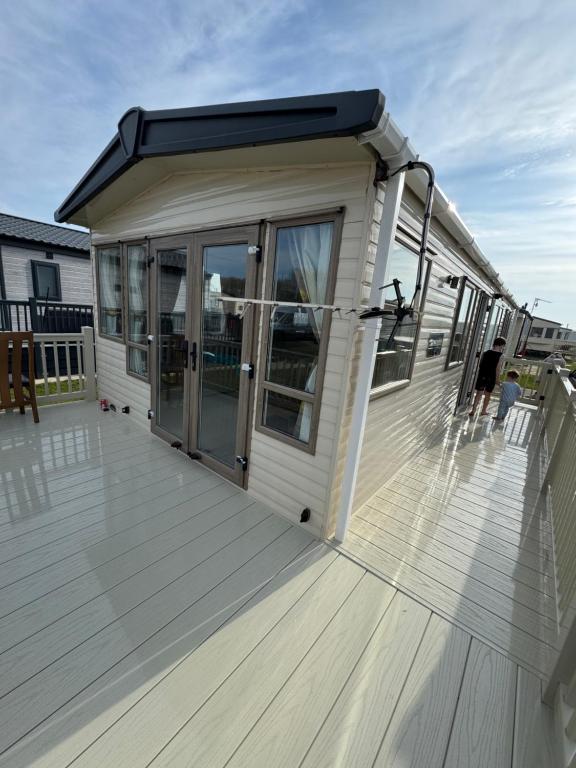 a house with a large deck with glass doors at Sandy Haven in Ingoldmells