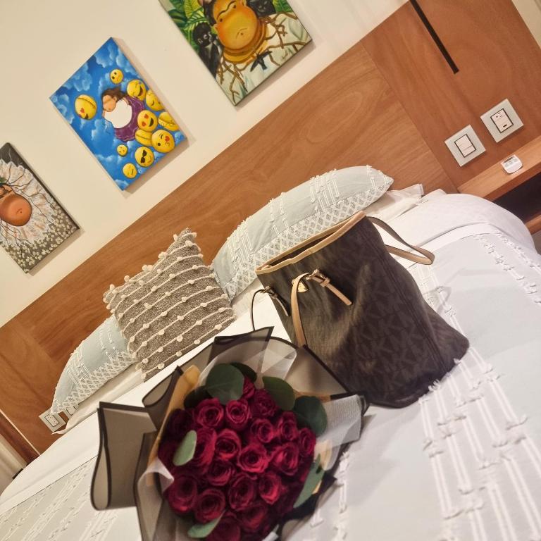 a bouquet of red roses and a purse on a bed at CASA DON JULIAN in Oaxaca City