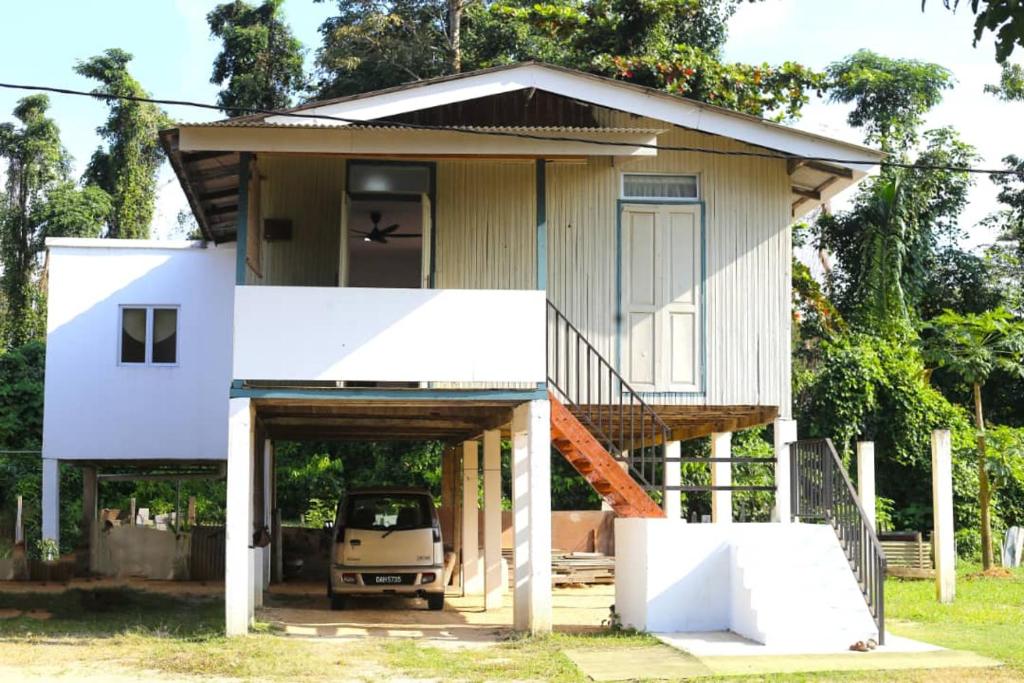 a house with a truck parked in front of it at Homestay Kota Bharu Tok Paloh in Kota Bharu