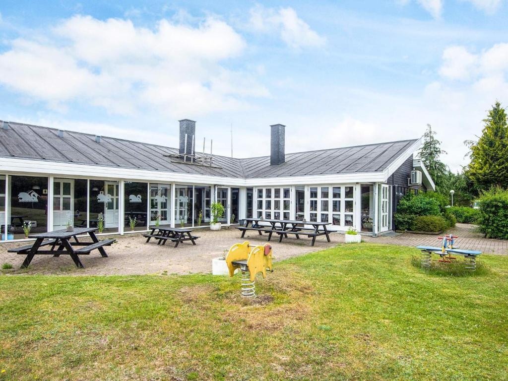 a building with picnic tables and picnic tables at 4 person holiday home in Hampen in Hampen