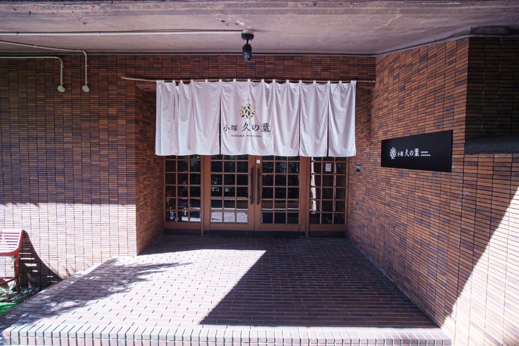 un bâtiment en briques avec une fenêtre avec un rideau blanc dans l'établissement Kozuka Hisanoha, à Hakone