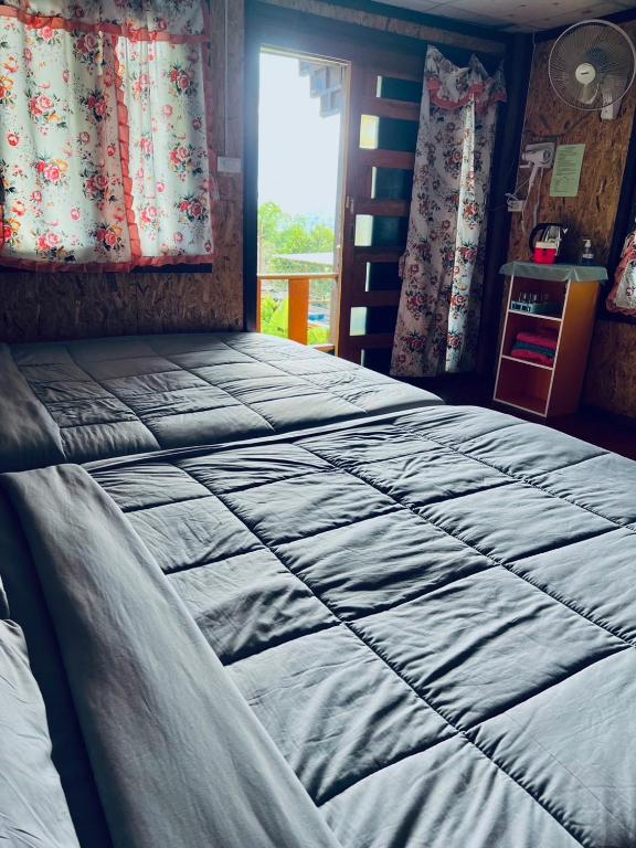 a large bed in a room with a window at รักเขาอินทนนท์โฮมสเตย์ Doi inthanon Homestay in Ban Yang Di Pha Mop
