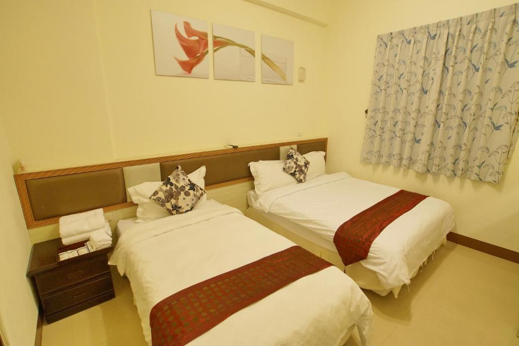 a hotel room with two beds and a window at Bang Qiaonuo - Peng&#39;s family in Taitung City