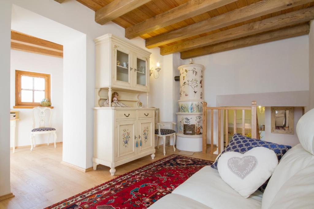een woonkamer met een witte bank en een hartkussen bij Casa Ursic Scrittore in Grimacco