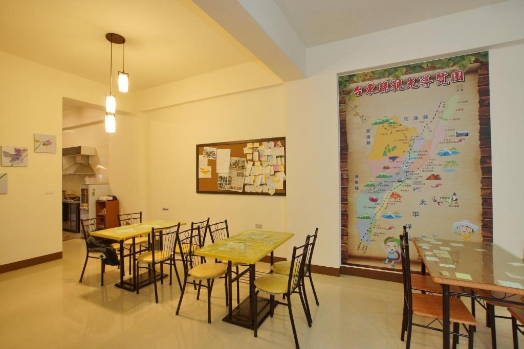 un restaurant avec des tables et des chaises et une grande carte sur le mur dans l'établissement Bang Qiaonuo - Peng's family, à Taïtung