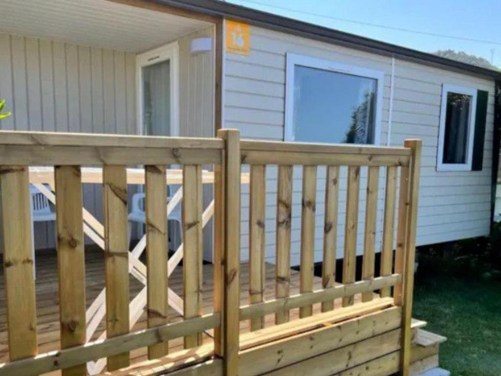 a wooden deck in front of a house at Mobil-home avec terrasse à Bretignolles-sur-Mer, 6 pers., 3 chambres - API-1-52-389 in Brétignolles-sur-Mer