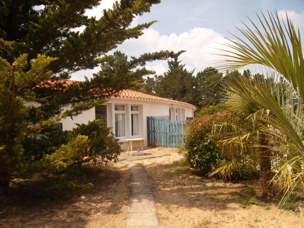 a small white house with a blue fence at Le Hameau de l'Ocean in Saint-Hilaire-de-Riez