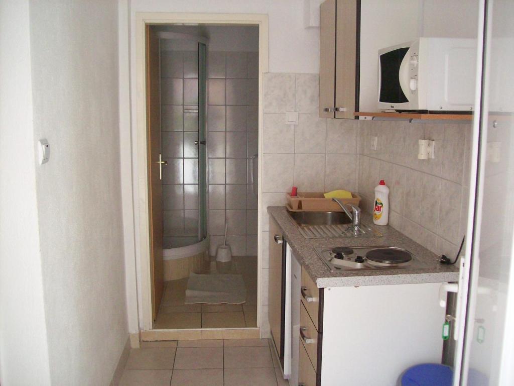 una pequeña cocina con ducha y lavabo en Apartments Dino, en Makarska