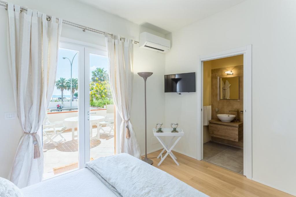 サン・ヴィート・ロ・カーポにあるSuite Faro 33のベッドルーム1室(ベッド1台付)、バスルーム(バルコニー付)