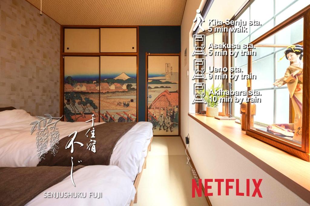 a bedroom with two beds and a painting on the wall at Senjushuku FUJI 101 北千住 in Tokyo