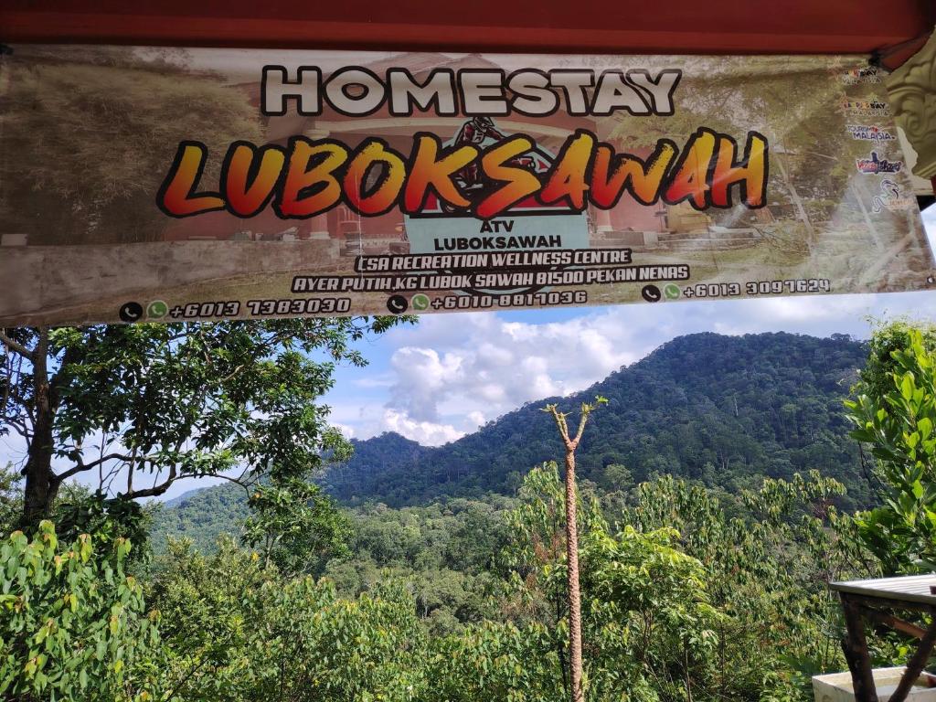 a view of the mountains through a window at Homestay LubokSawah in Pekan Nanas