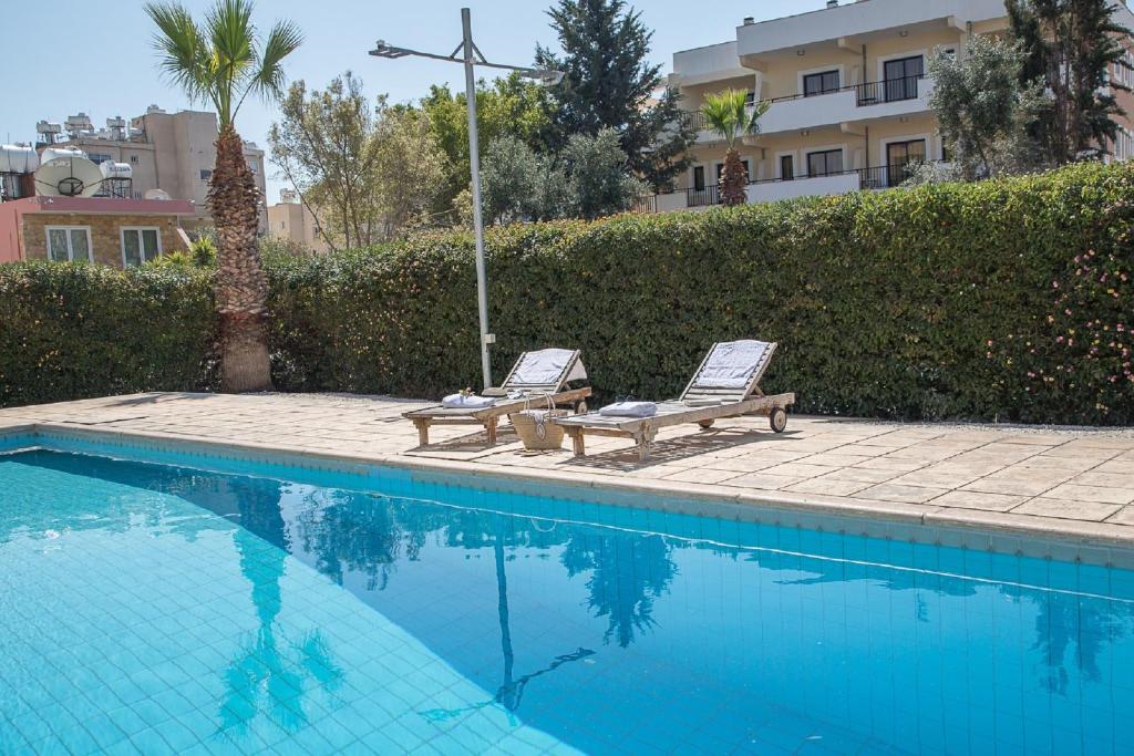 two lounge chairs sitting next to a swimming pool at Paphos Love Shack apartment in Paphos City