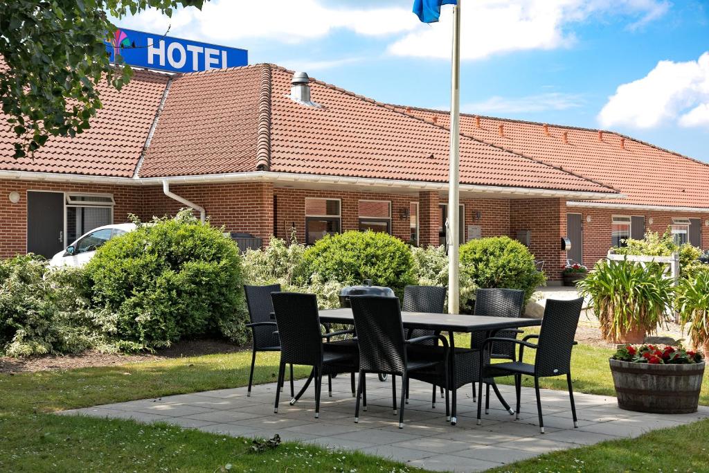 una mesa y sillas frente a un hotel en Hotel Varde en Varde