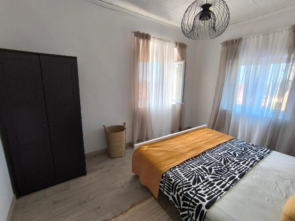 1 dormitorio con 1 cama, armario negro y ventana en Bocel, en Mali Lošinj