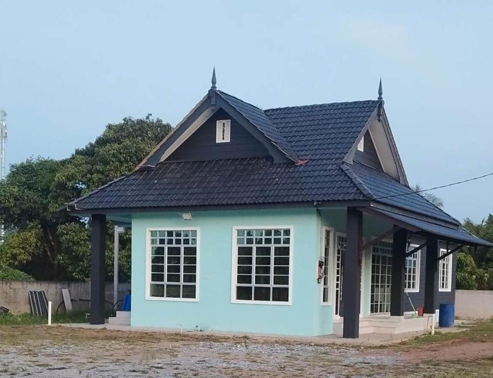 a small blue house with a black roof at Homestay Singgah Tok Dir in Kuala Terengganu