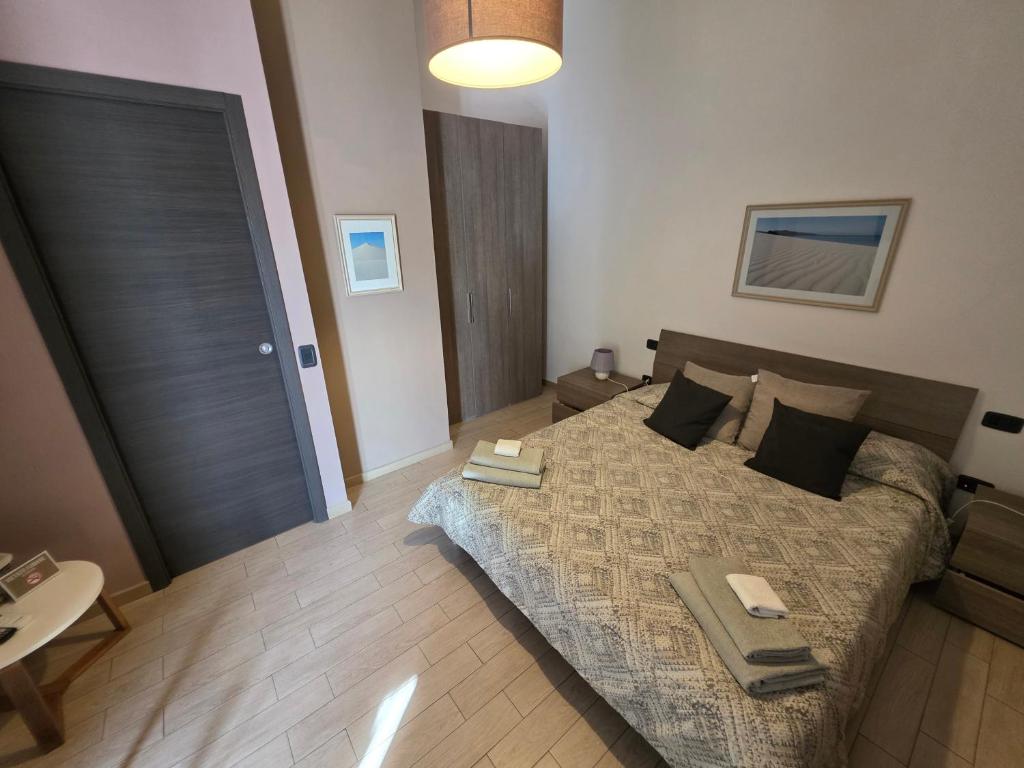 a bedroom with a bed and a table and a door at Le Dune Bed & Breakfast in SantʼAnna Arresi