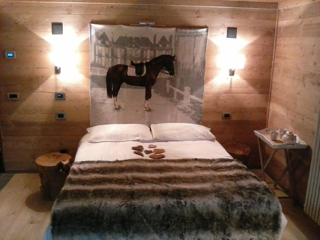 a bedroom with a bed with a horse painting on the wall at LTHorses & Dreams in La Thuile