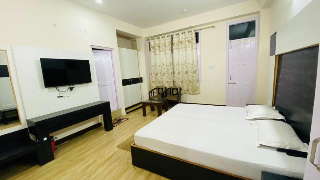a bedroom with a bed and a flat screen tv at Pahadi Zayka Homestay in Chail