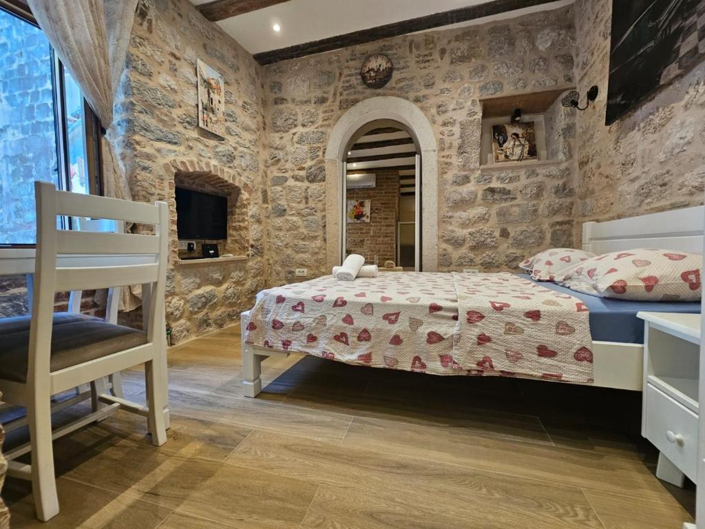 a bedroom with a bed and a stone wall at Patrik Patrik in Kotor