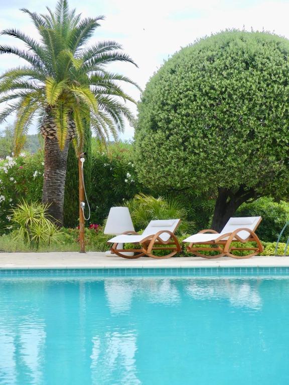 a group of lounge chairs next to a swimming pool at La Rose des Sables suite 5 étoiles villa Côté Cœur in Les Issambres