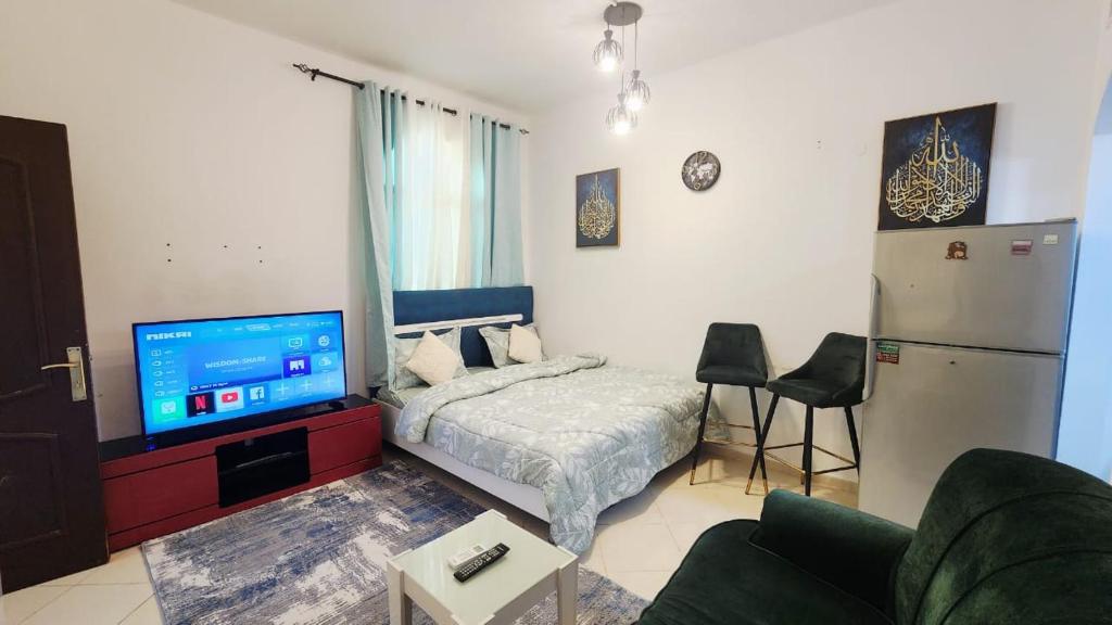 a bedroom with a bed and a tv and a couch at Family Room in Abu Dhabi